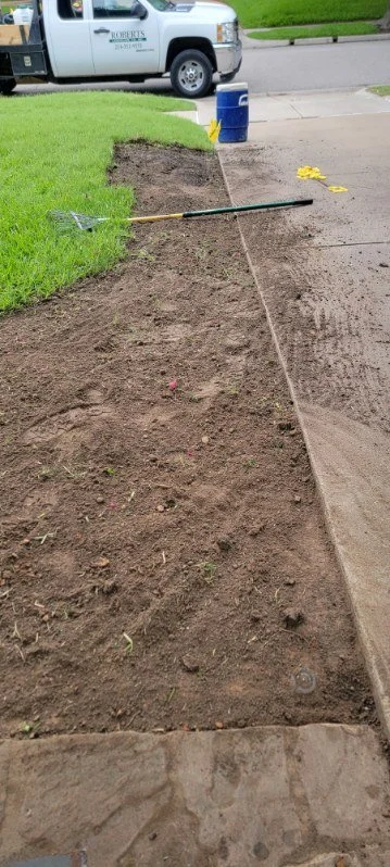 Soil prepared alongside a concrete driveway